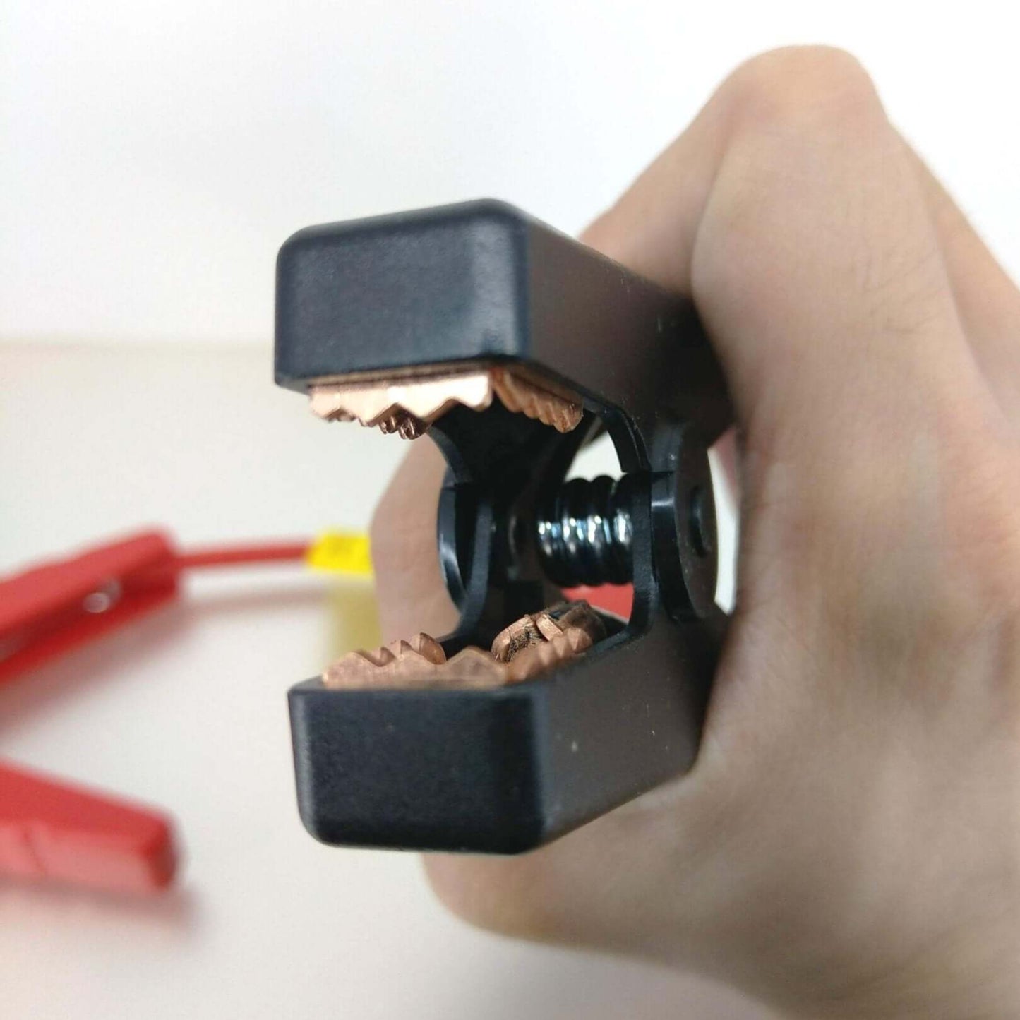 Close-up of alligator clip jaws for jump starter cables, demonstrating gripping teeth and design for EC5 connector use.