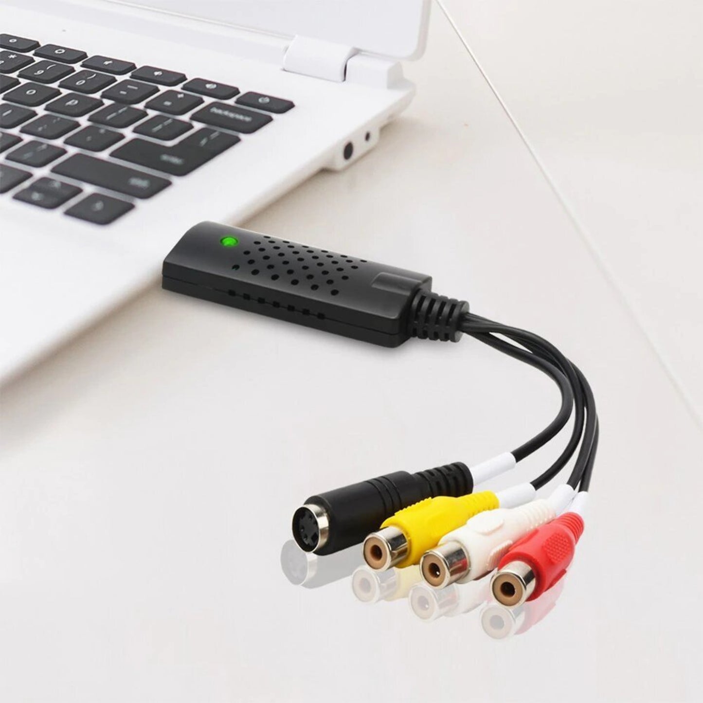 USB 2.0 Video Capture Card connected to a laptop, featuring RCA connectors for video and audio conversion.