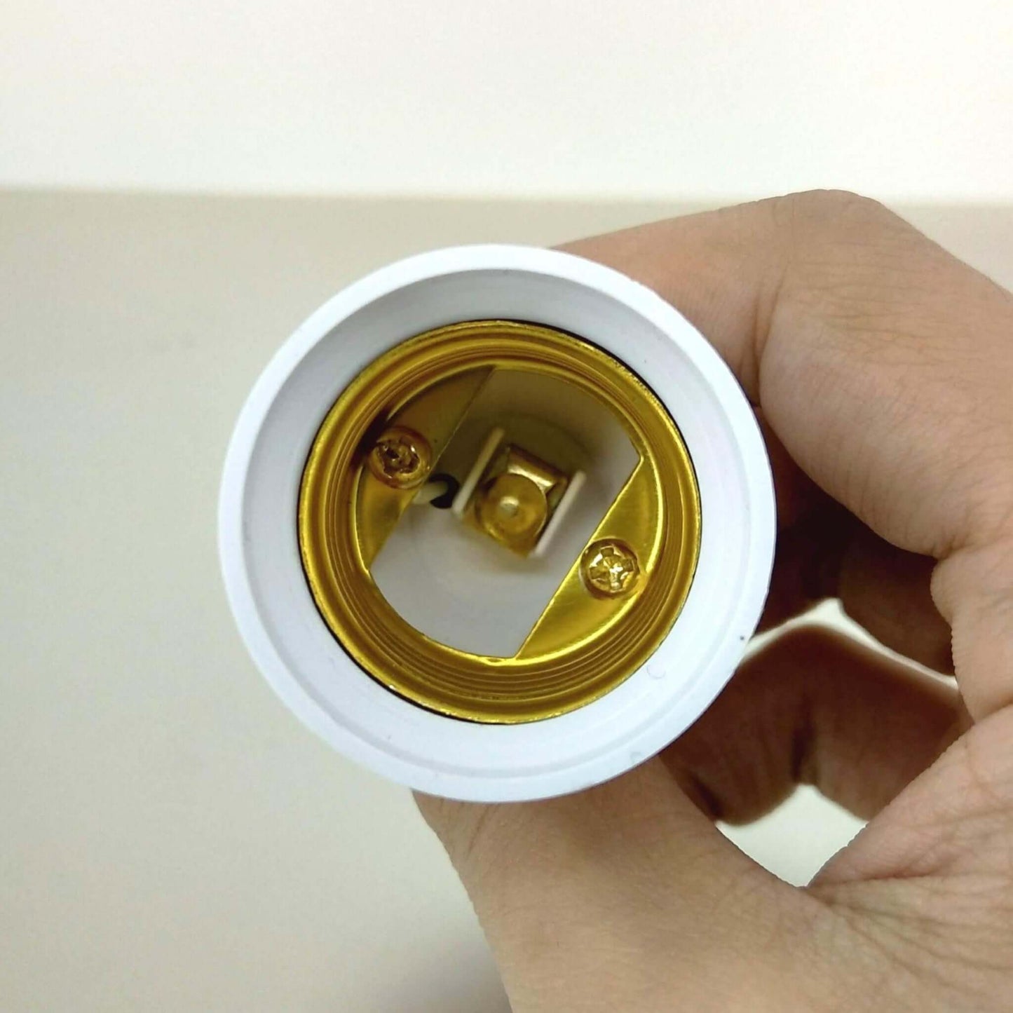 Close-up of E14 to E27 lamp holder converter adapter, showcasing the interior screw base connection.