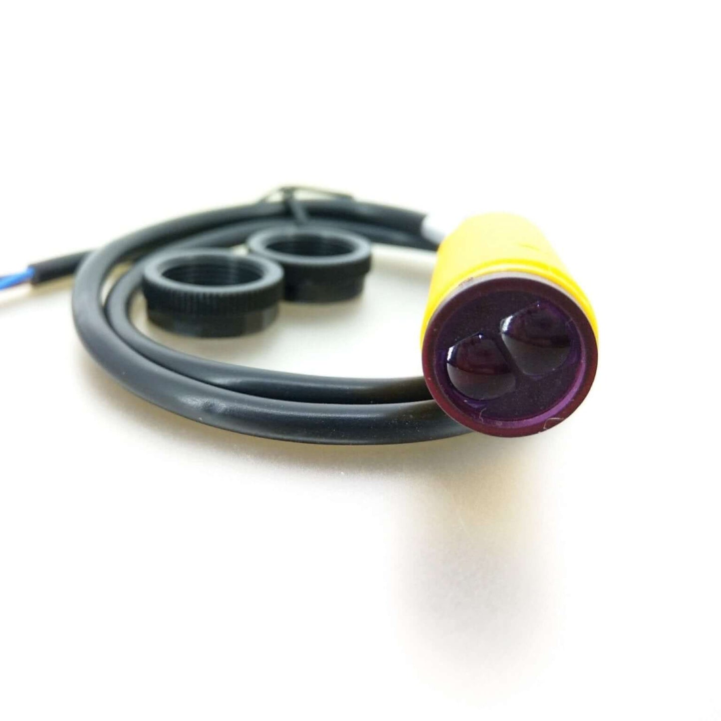 E18-D80NK adjustable infrared sensor with yellow casing for obstacle detection, featuring two lenses and connectors.