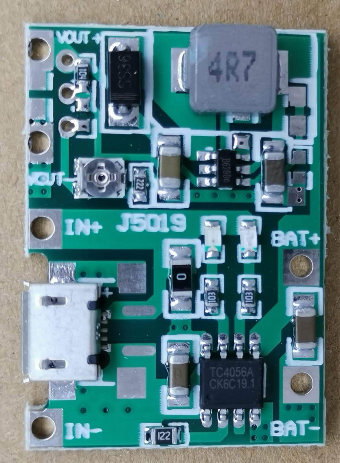 Adjustable 3.7V lithium battery boost charger module circuit board with USB input and output connections.