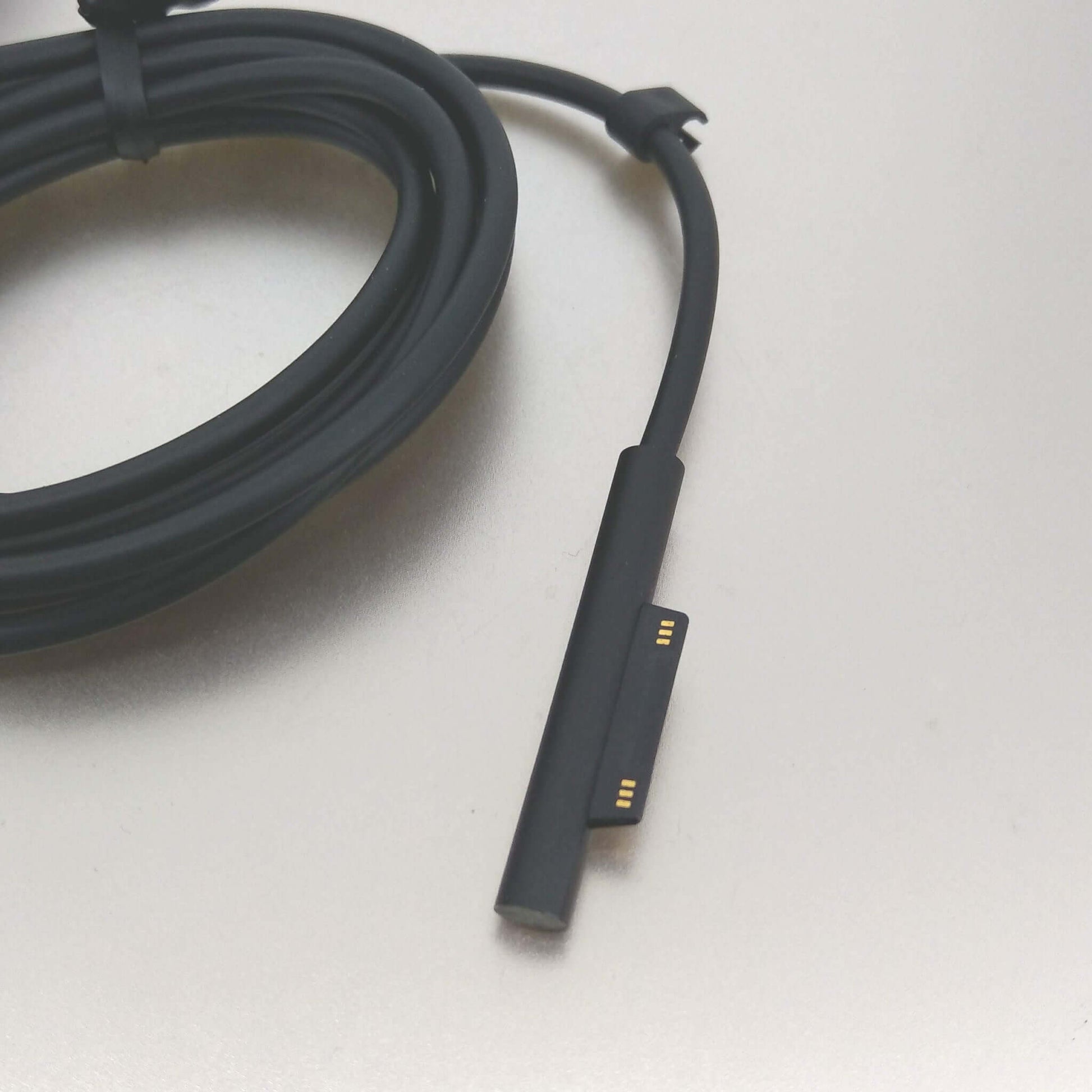 Close-up of Microsoft Surface 65W charger connector cable, featuring magnetic attachment for easy connection.