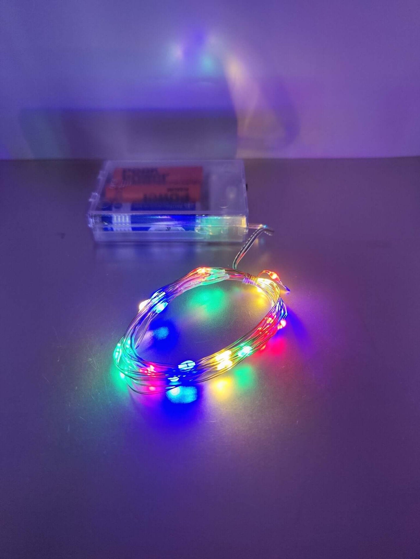 Multicolor LED fairy lights on silver wire, battery-operated for festive and cozy décor.