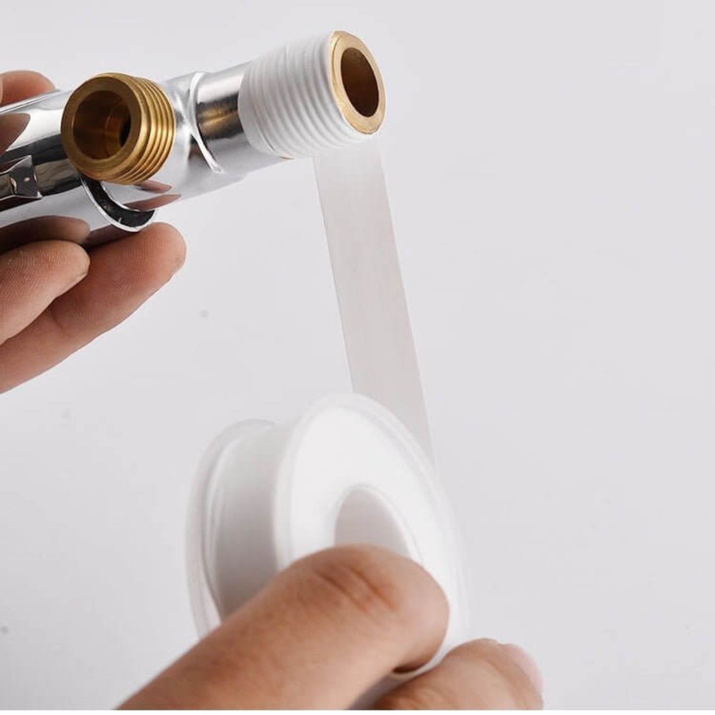 Hand applying PTFE thread seal tape to a threaded pipe for secure water and gas seals.