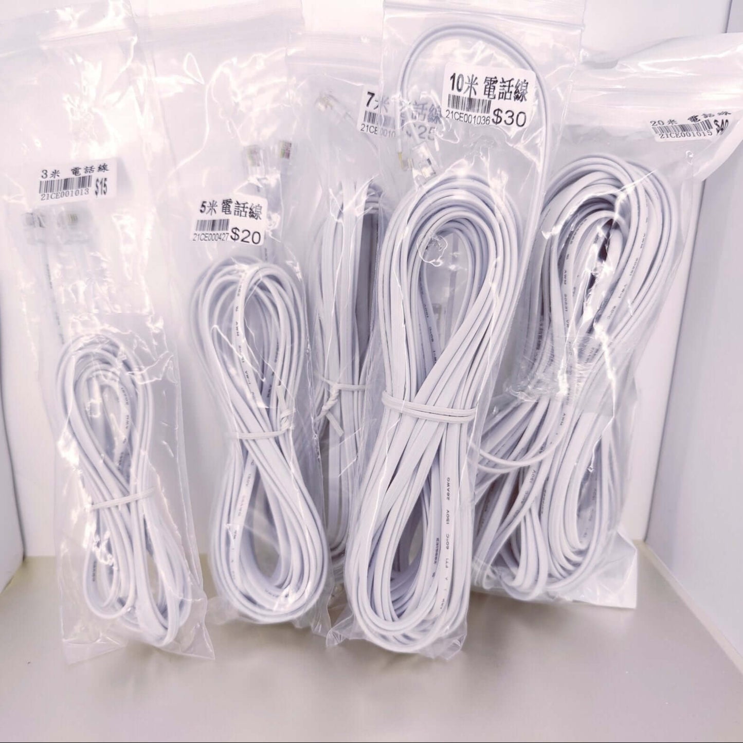 Assorted RJ11 telephone and modem extension cables in clear packaging, showing different lengths from 3M to 20M.