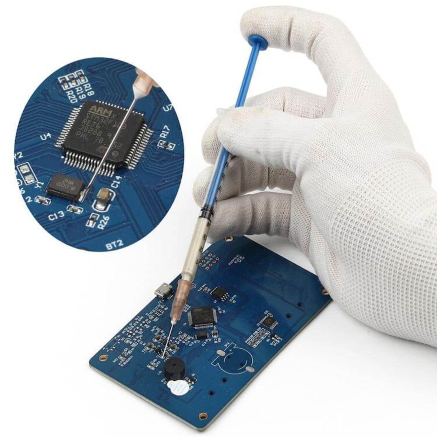 Applying silver conductive paint to a circuit board for repairing a PCB trace.