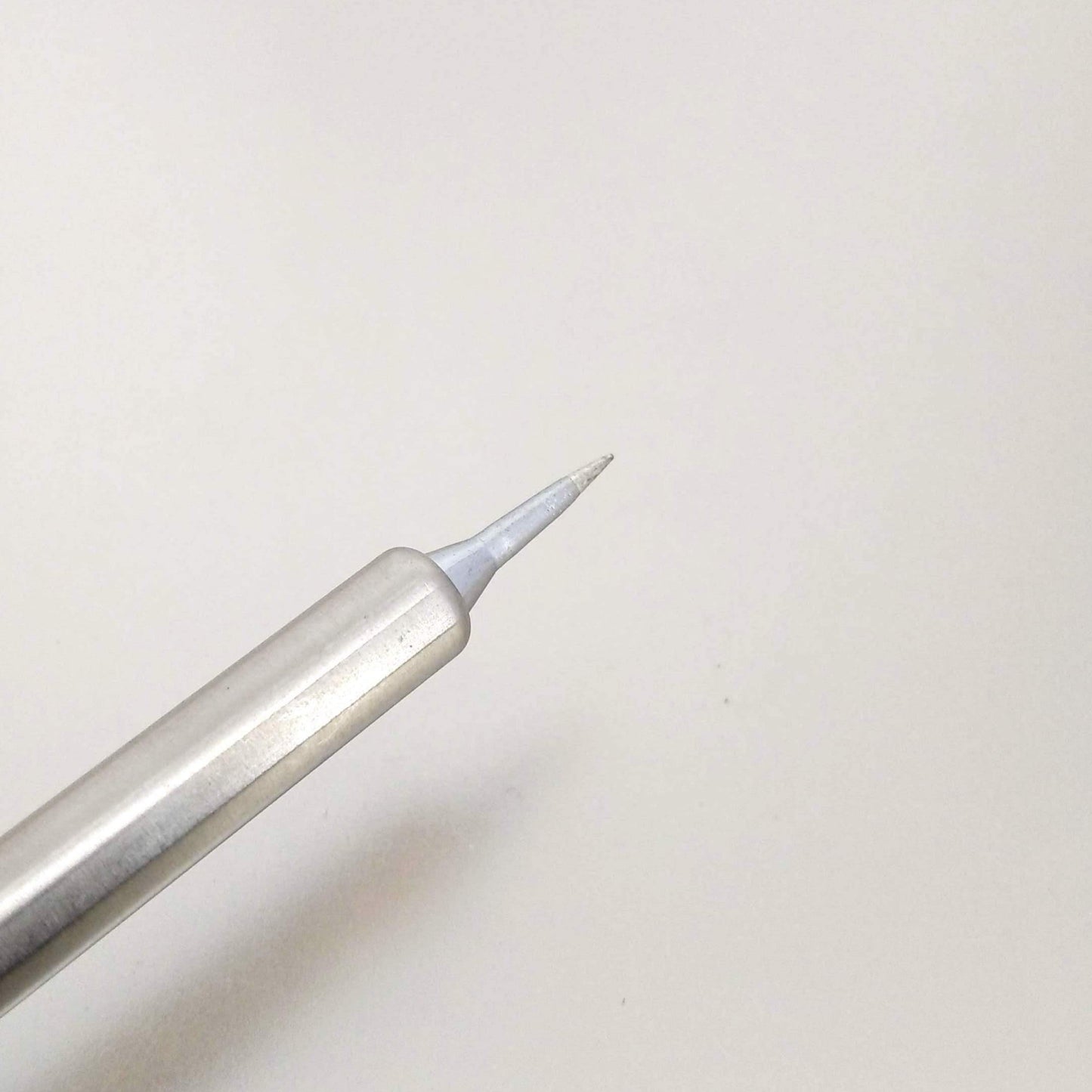 Close-up of a precision tip of a silver soldering iron, highlighting the fine point for detailed soldering tasks.