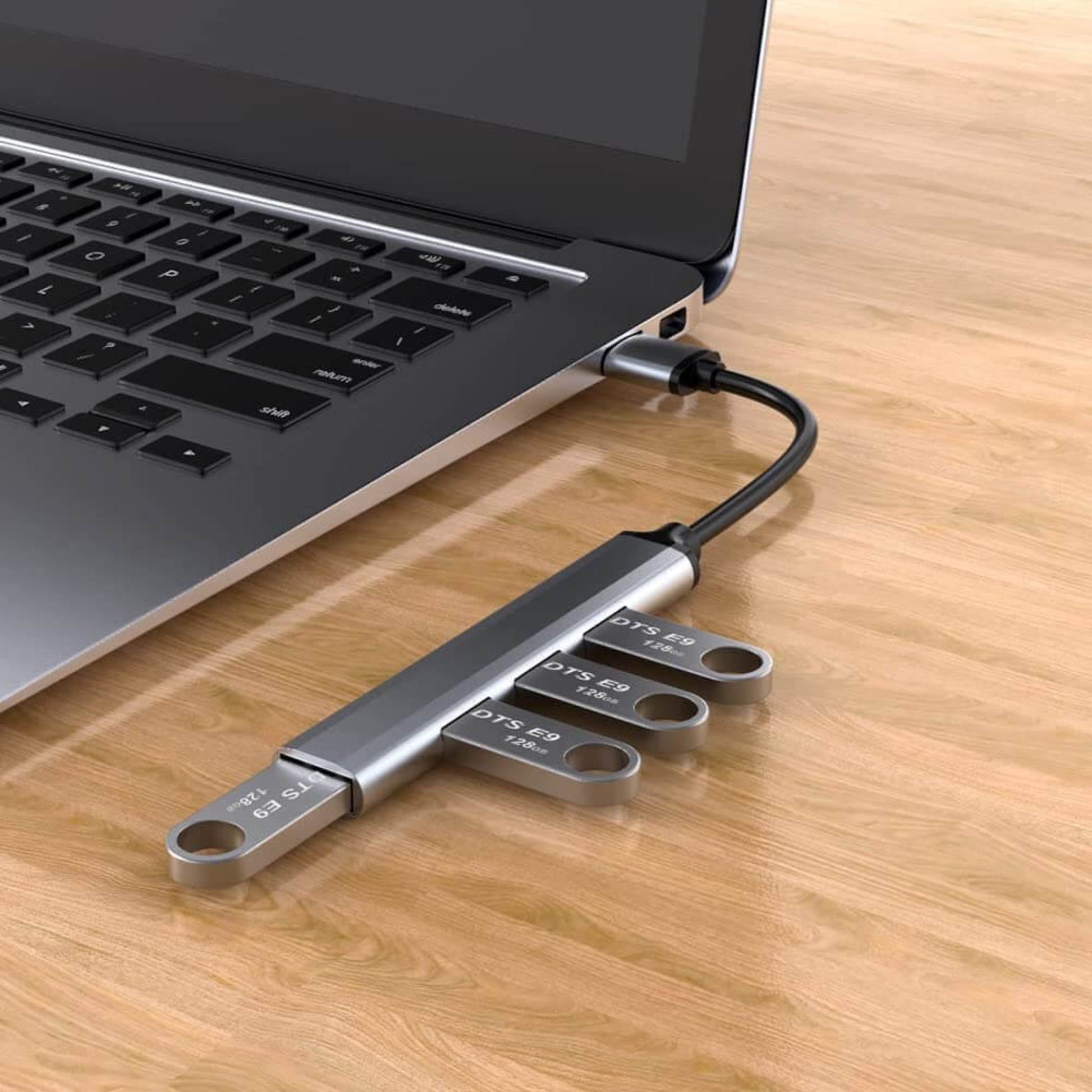 USB 3.0 aluminum alloy 4-port hub connected to a laptop, featuring ultra-slim design and extended cable for easy use.