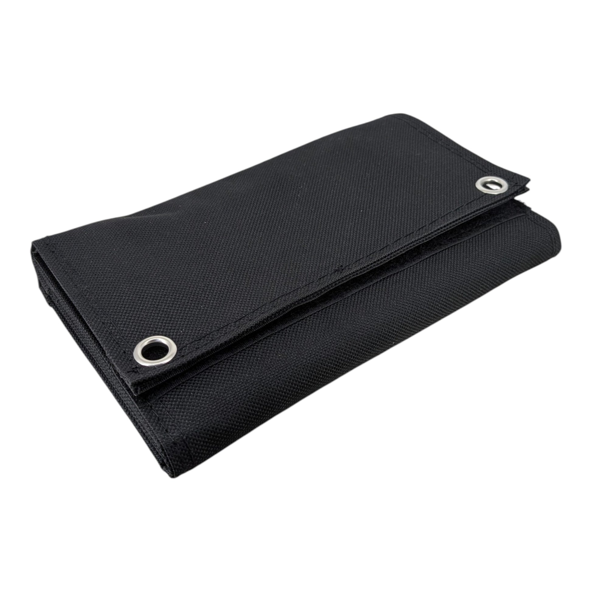 Folded black 10W portable solar panel showing its compact, wallet-like size and durable waterproof fabric with metal mounting grommets.