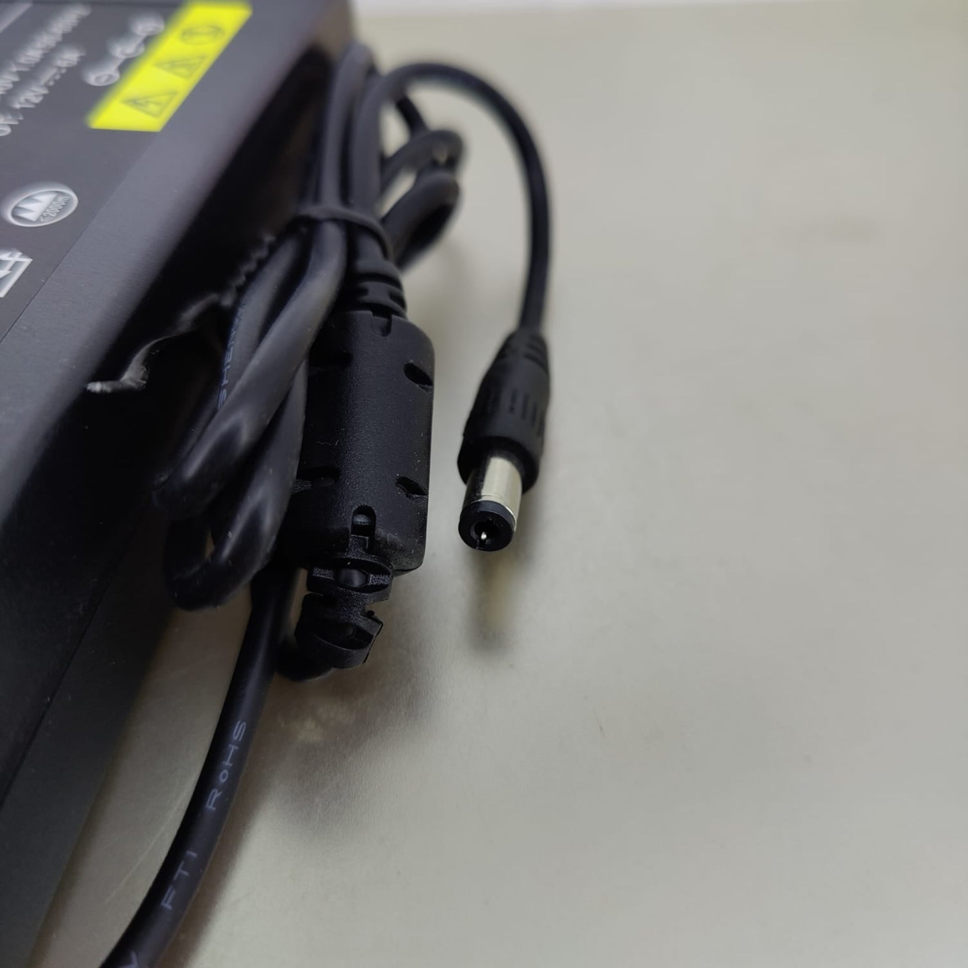 Close-up of the 5.5mm x 2.5mm DC barrel jack connector on the 12V 6A power adapter.