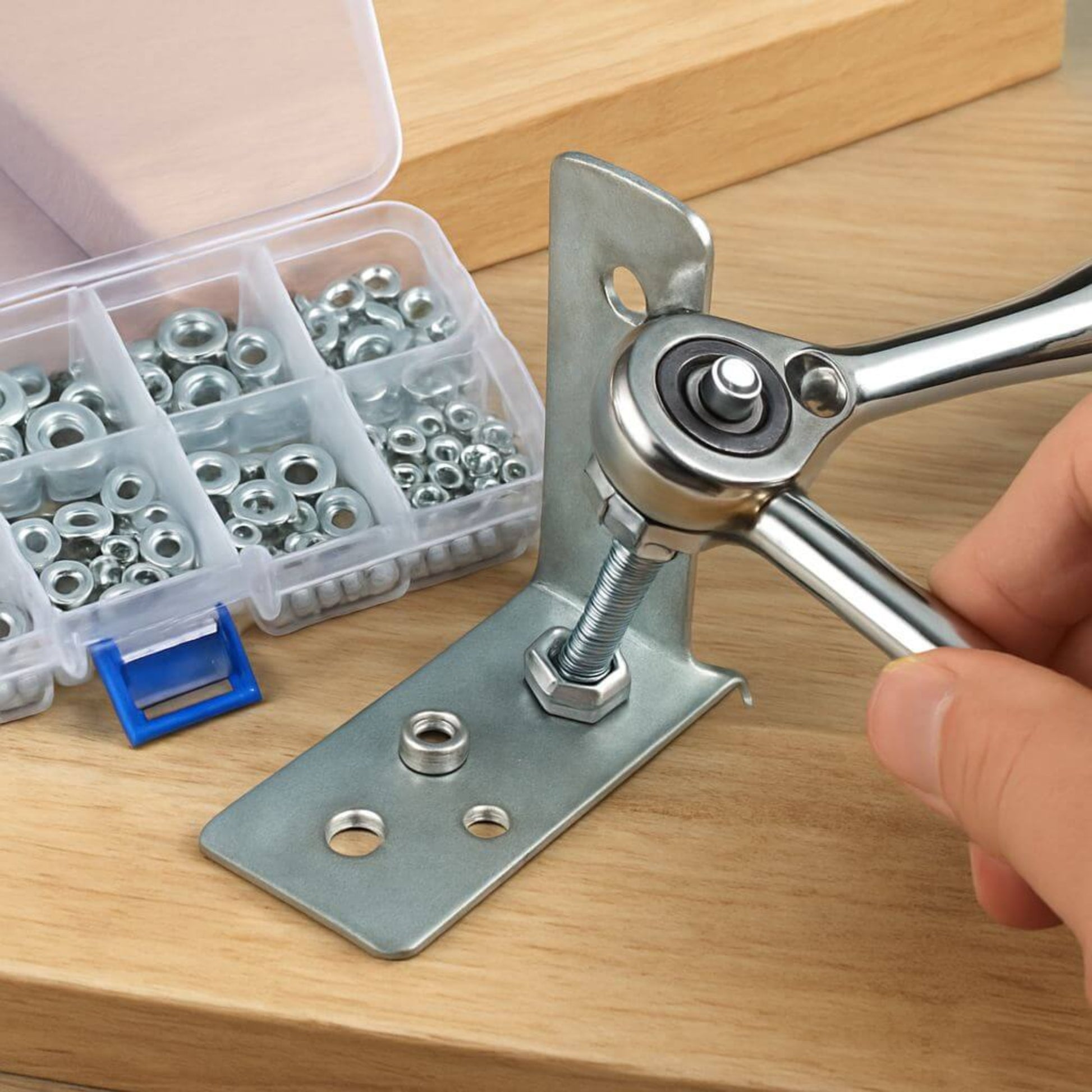 Person using a wrench on a stainless steel hex nut while installing on a metal bracket, with a box of assorted nuts beside.