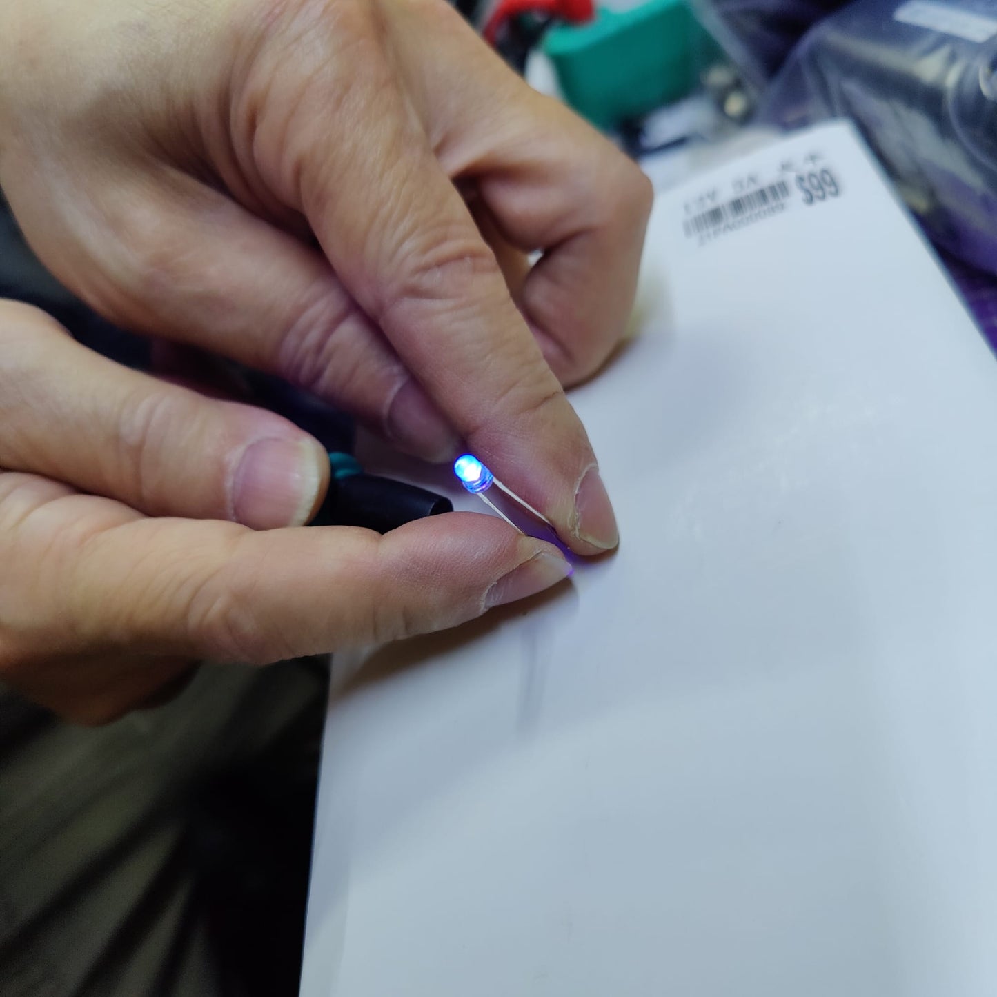 Close up of 3mm UV LED lit up showing bright violet 395nm output in hand.