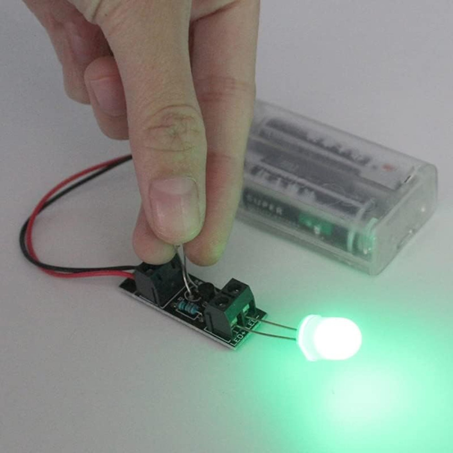 3V Intelligent Light Control Sensor Switch Module in use, powering a green LED with a light sensor.