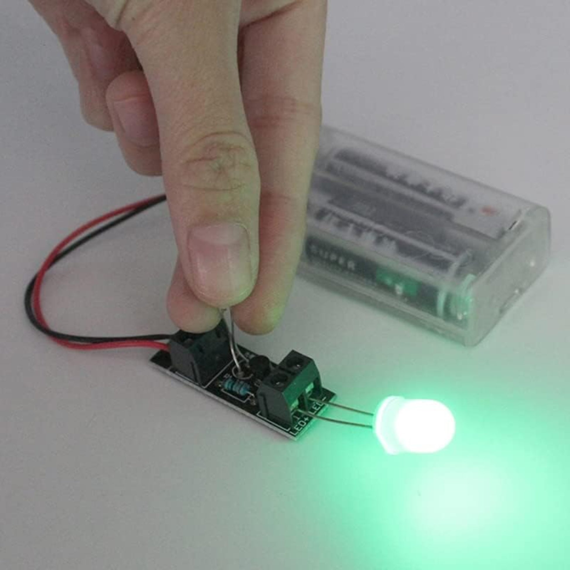3V Intelligent Light Control Sensor Switch Module in use, powering a green LED with a light sensor.