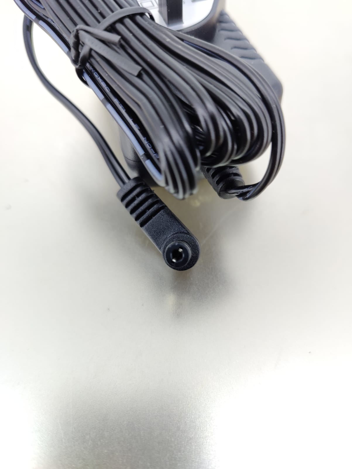 Close-up of a 5.5mm x 2.1mm DC plug connector from a 5V 2.5A universal AC/DC power adapter.