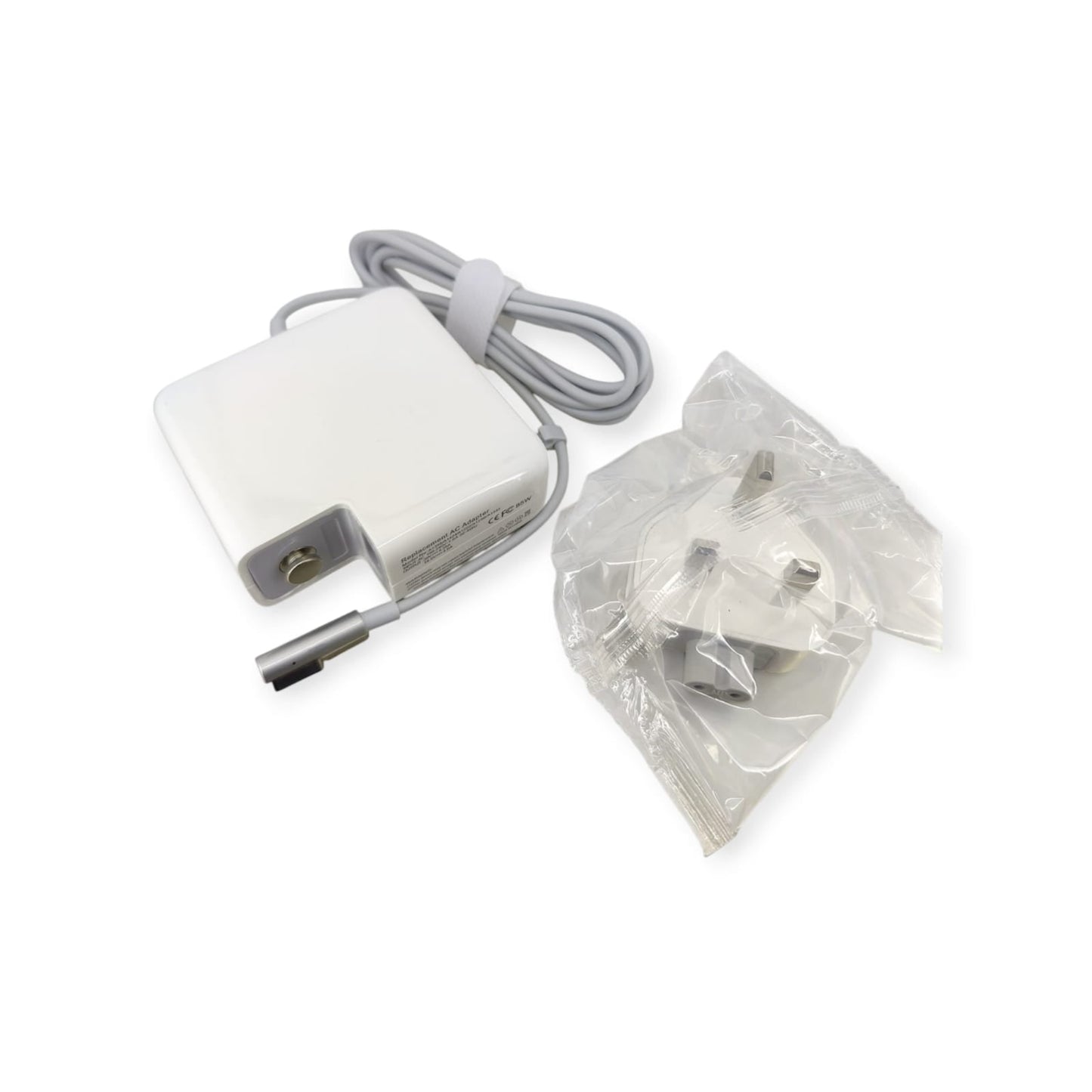 Full kit of 85W MagSafe 1 replacement power adapter with cable, shown next to a packaged UK 3-pin plug.