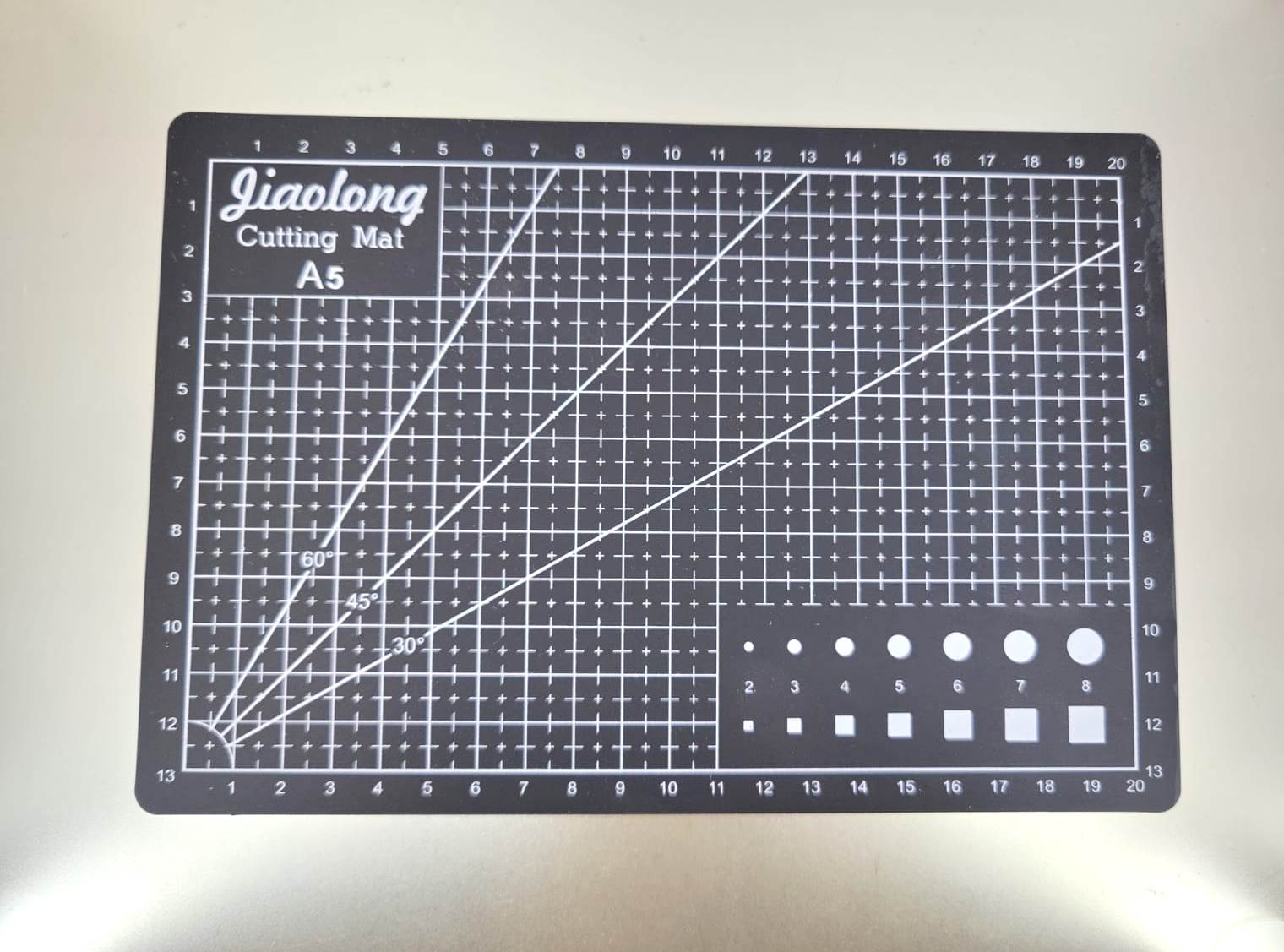 A5 cutting mat with grid lines for sewing and crafts, designed for durability and precision in fabric cutting.