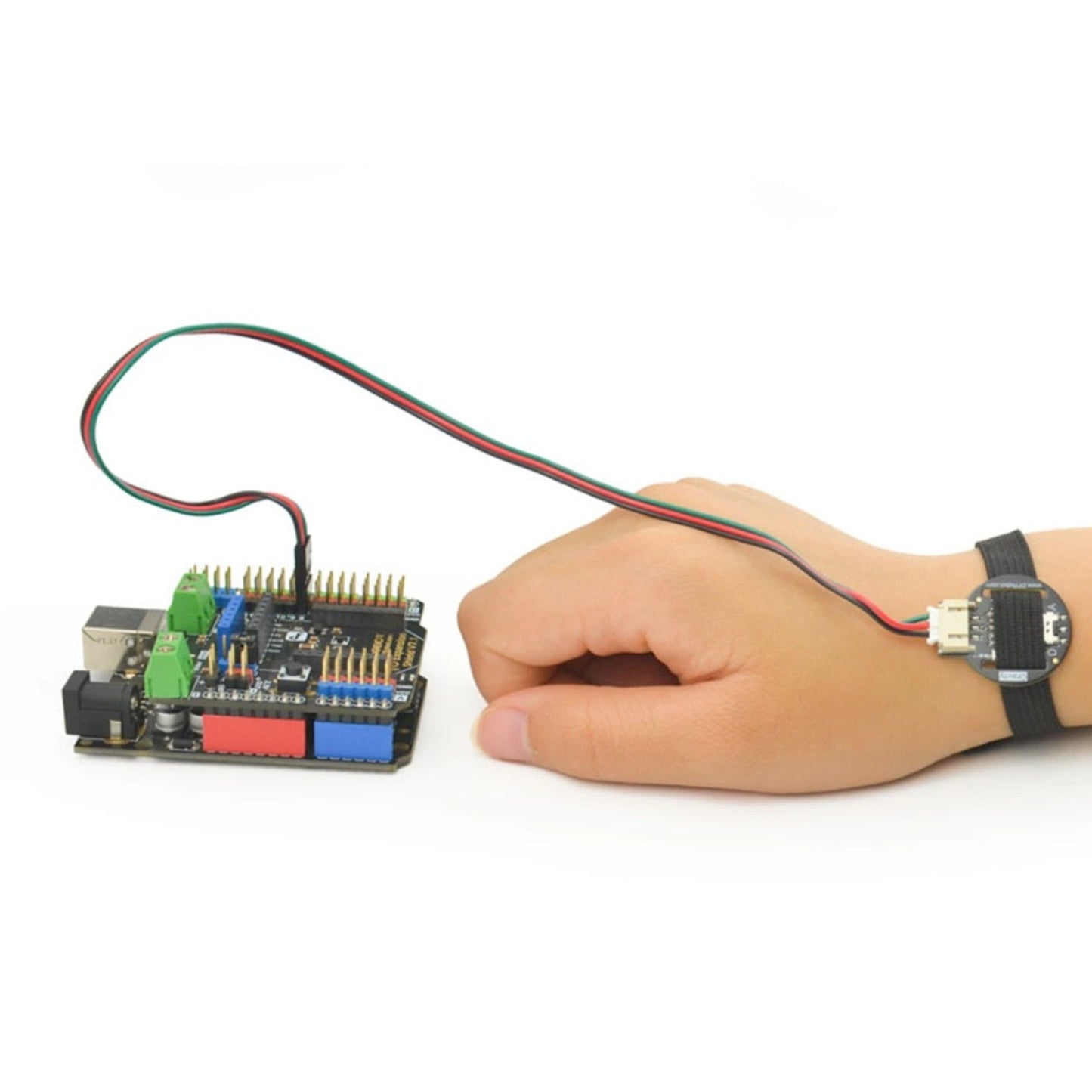 A user wearing the DFRobot heart rate monitor sensor on their wrist, connected to an Arduino microcontroller via an IO expansion shield.