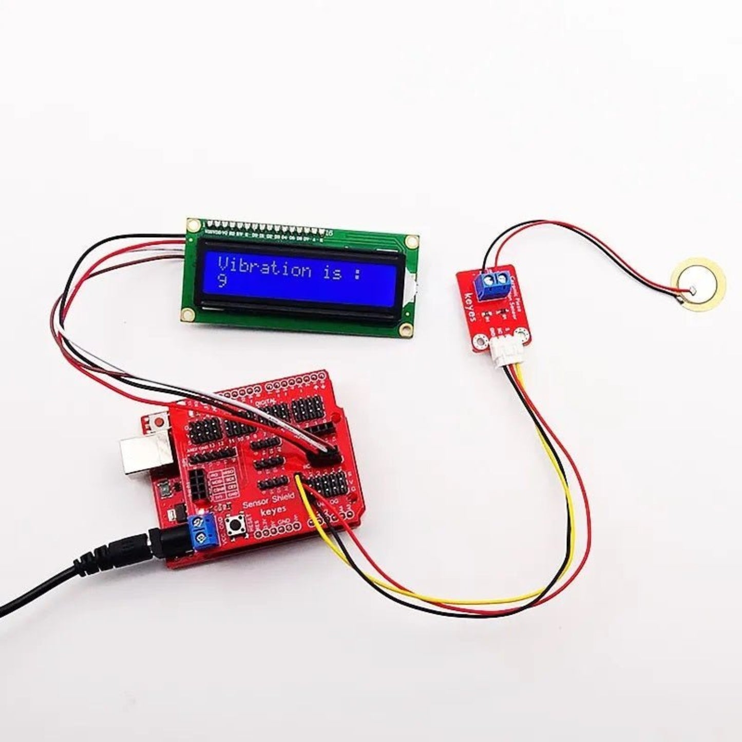 Arduino setup with piezoelectric ceramic vibration sensor module and LCD display showing vibration measurement.