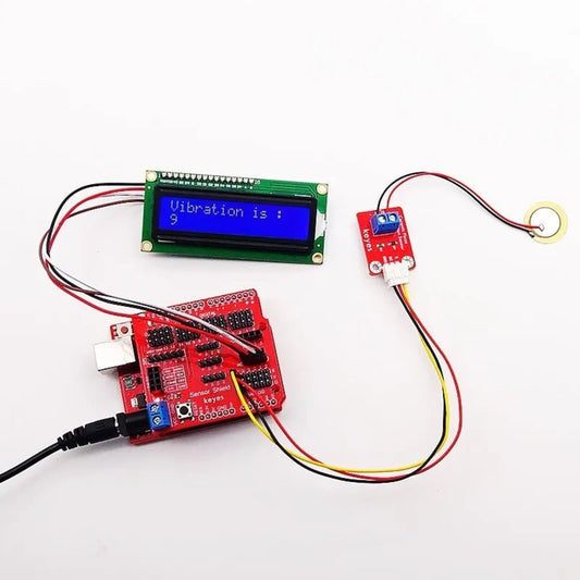 Arduino setup with piezoelectric ceramic vibration sensor module and LCD display showing vibration measurement.