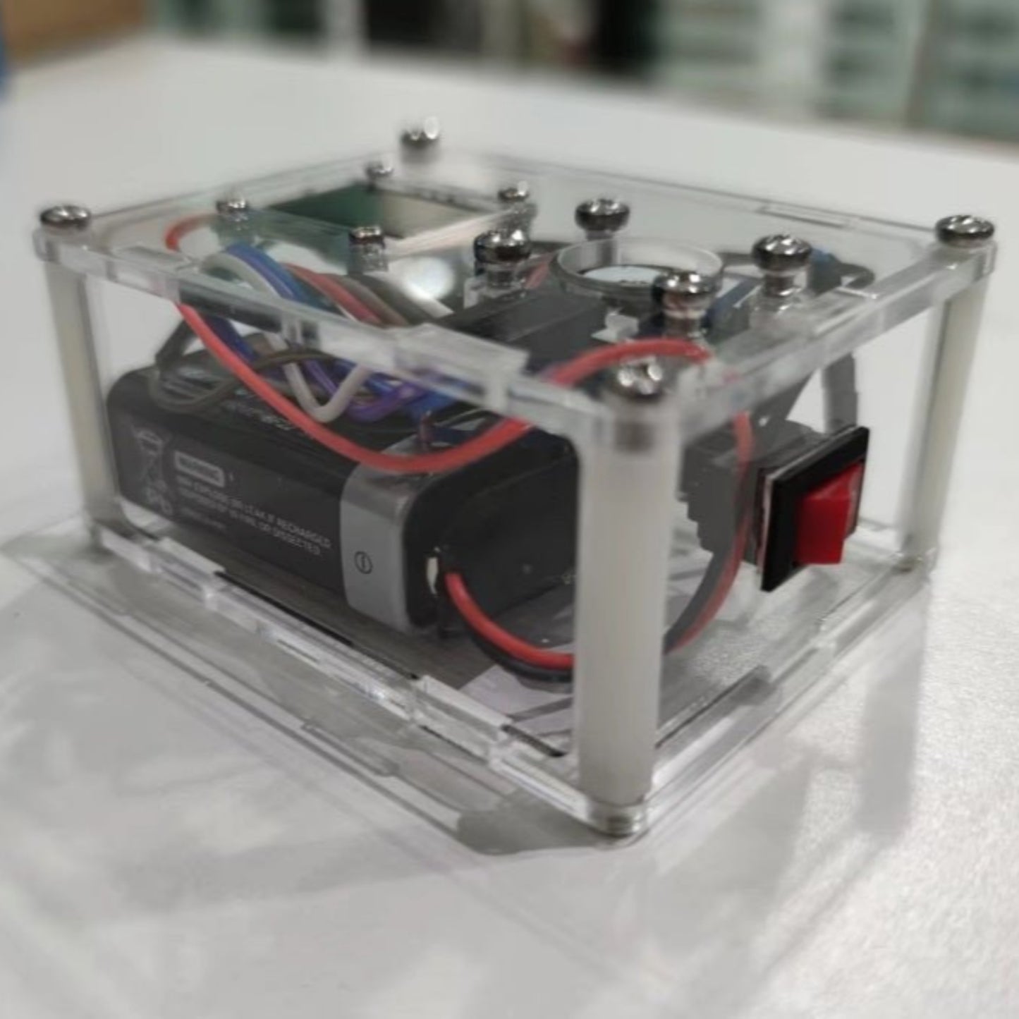 Heart rate monitoring module for Arduino in a clear plastic case, showcasing wiring and battery connections.