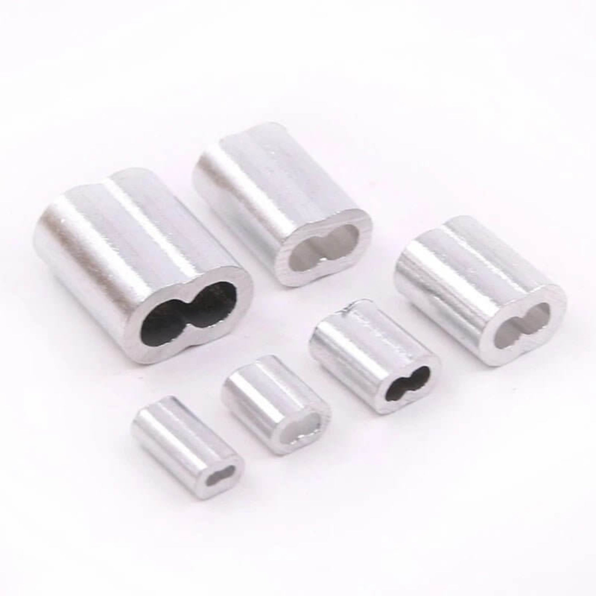 A collection of various sizes of aluminum double barrel ferrules for wire rope.