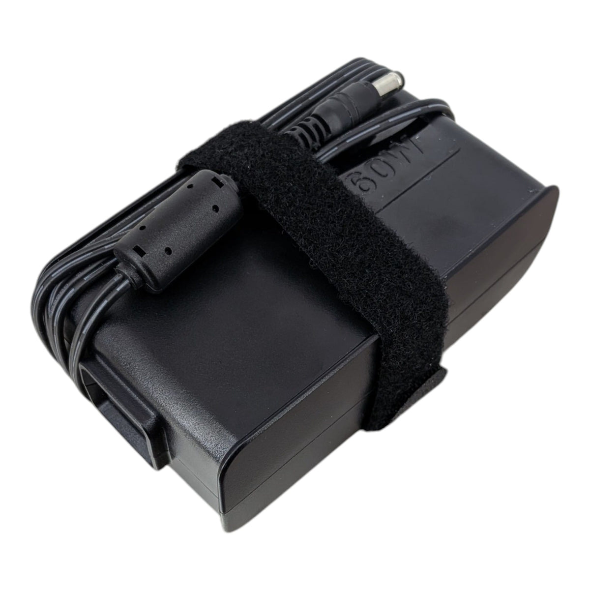 A black laptop power adapter with a coiled cable secured by a black velcro strap, shown on a plain white background.