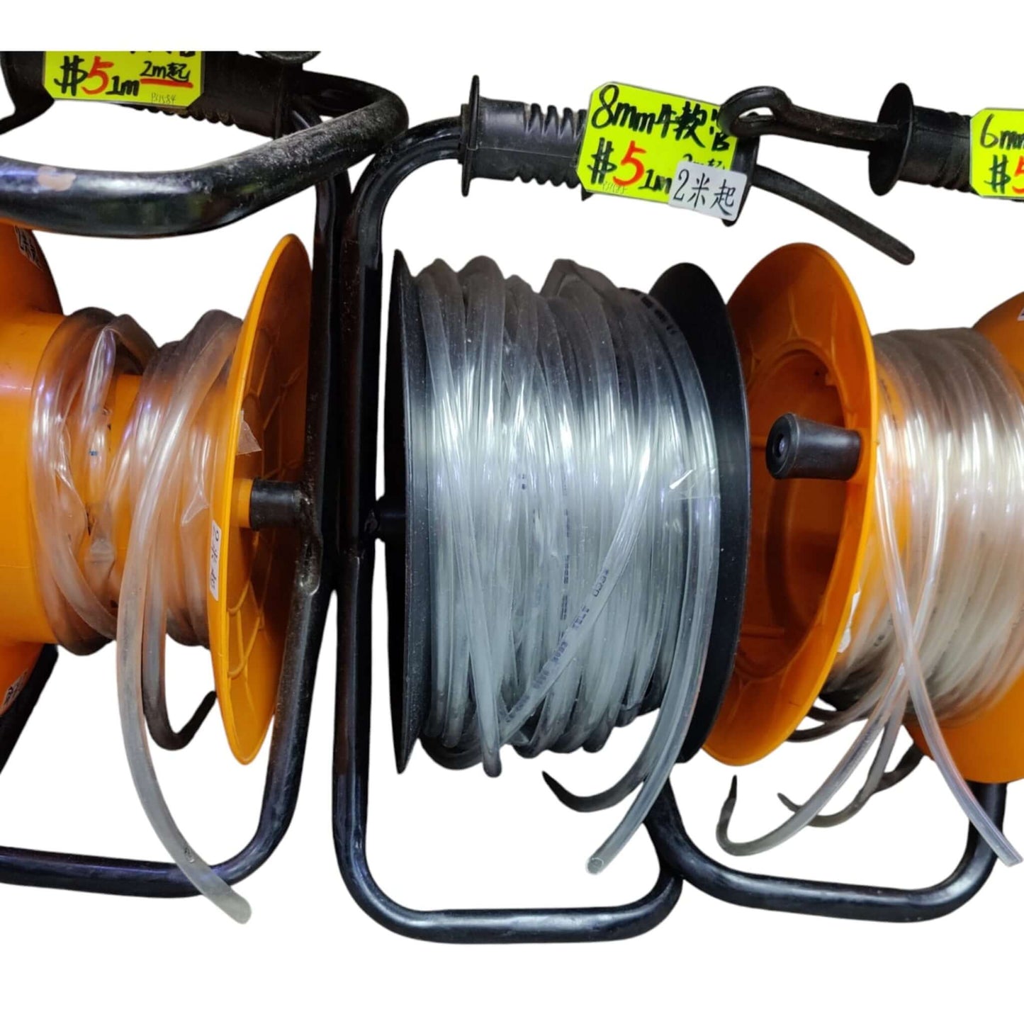 Rolls of transparent flexible PVC tubing on retail display rack showing 2m price tags.