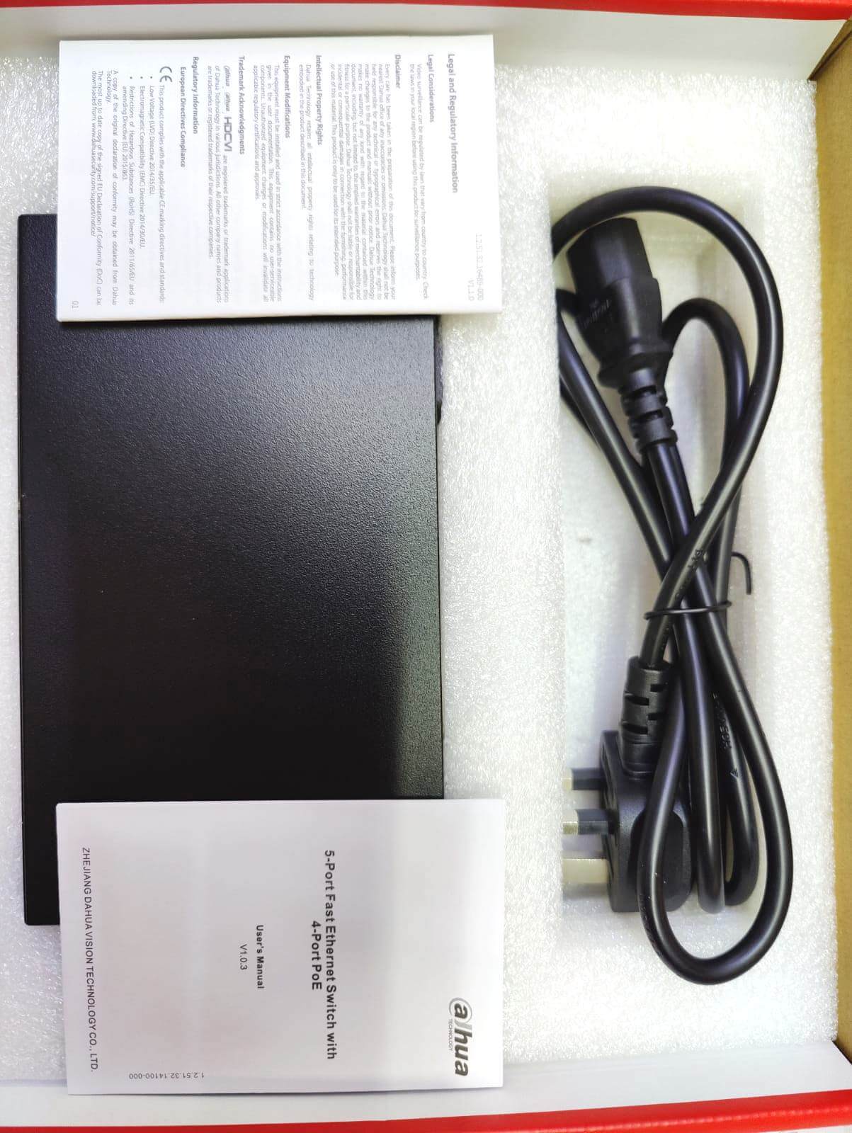 Dahua PFS3005-4ET-36 PoE switch packaging, featuring the unit, power cable, and user manual.
