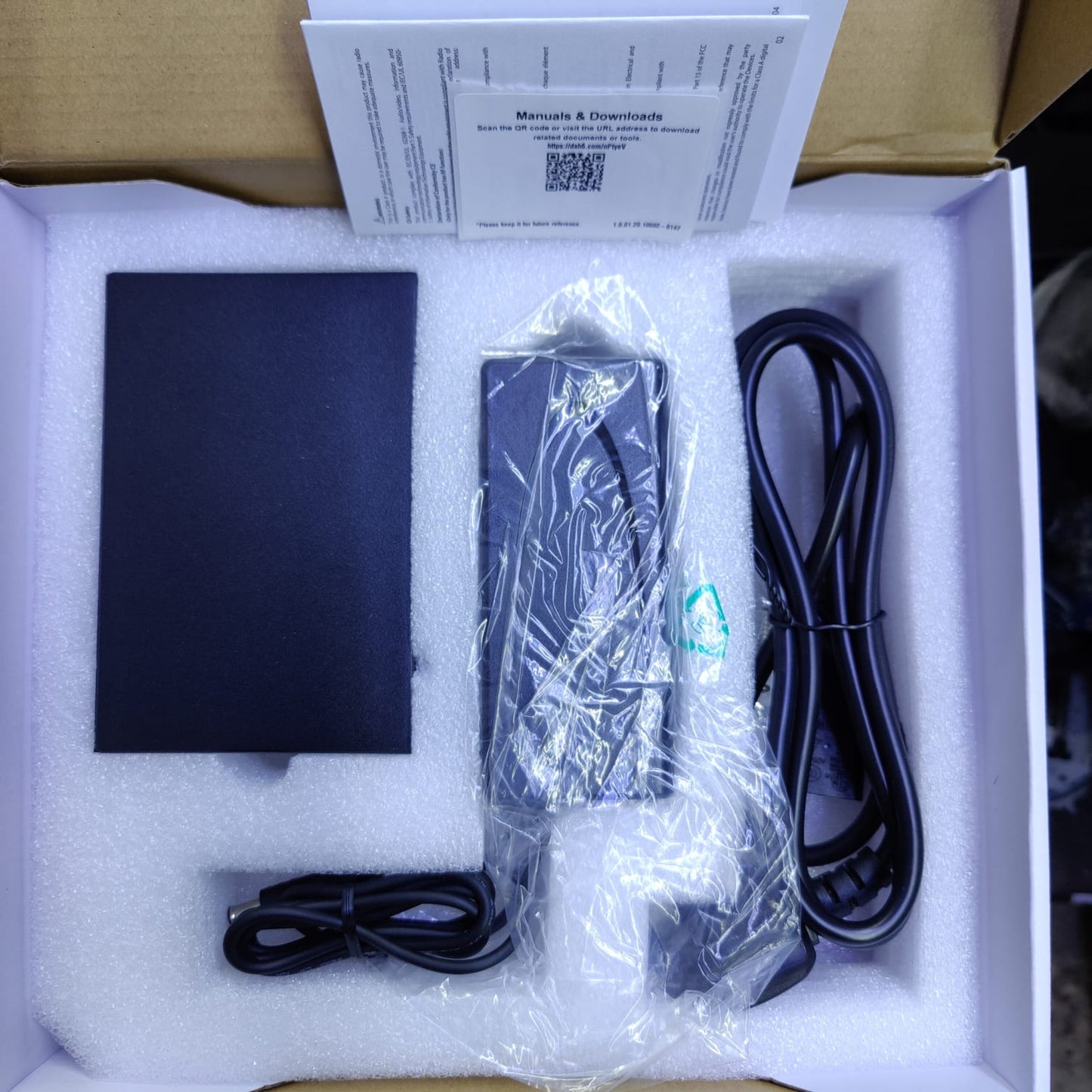 DAHUA 4-port PoE switch unboxing, showing device, power adapter, and manual. Easy installation for network setup.