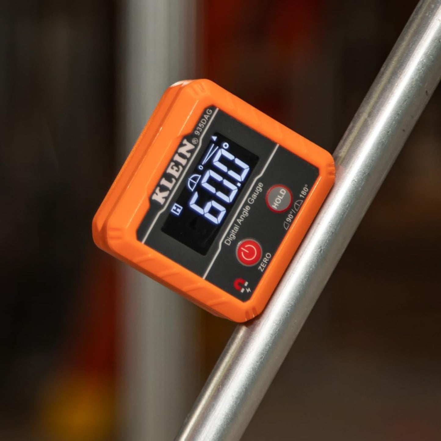 Digital inclinometer measuring 60 degree angle on a metal pipe.