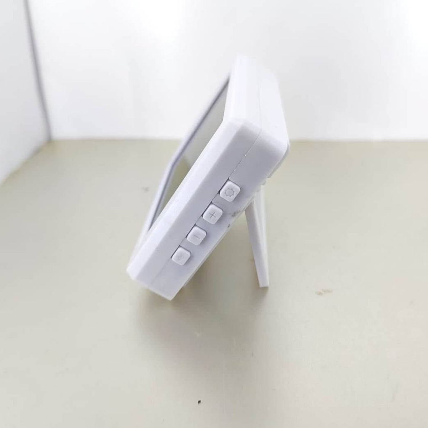 Side view of the slim electronic thermohygrometer. Shows the function control buttons for setting the time and alarm clock.