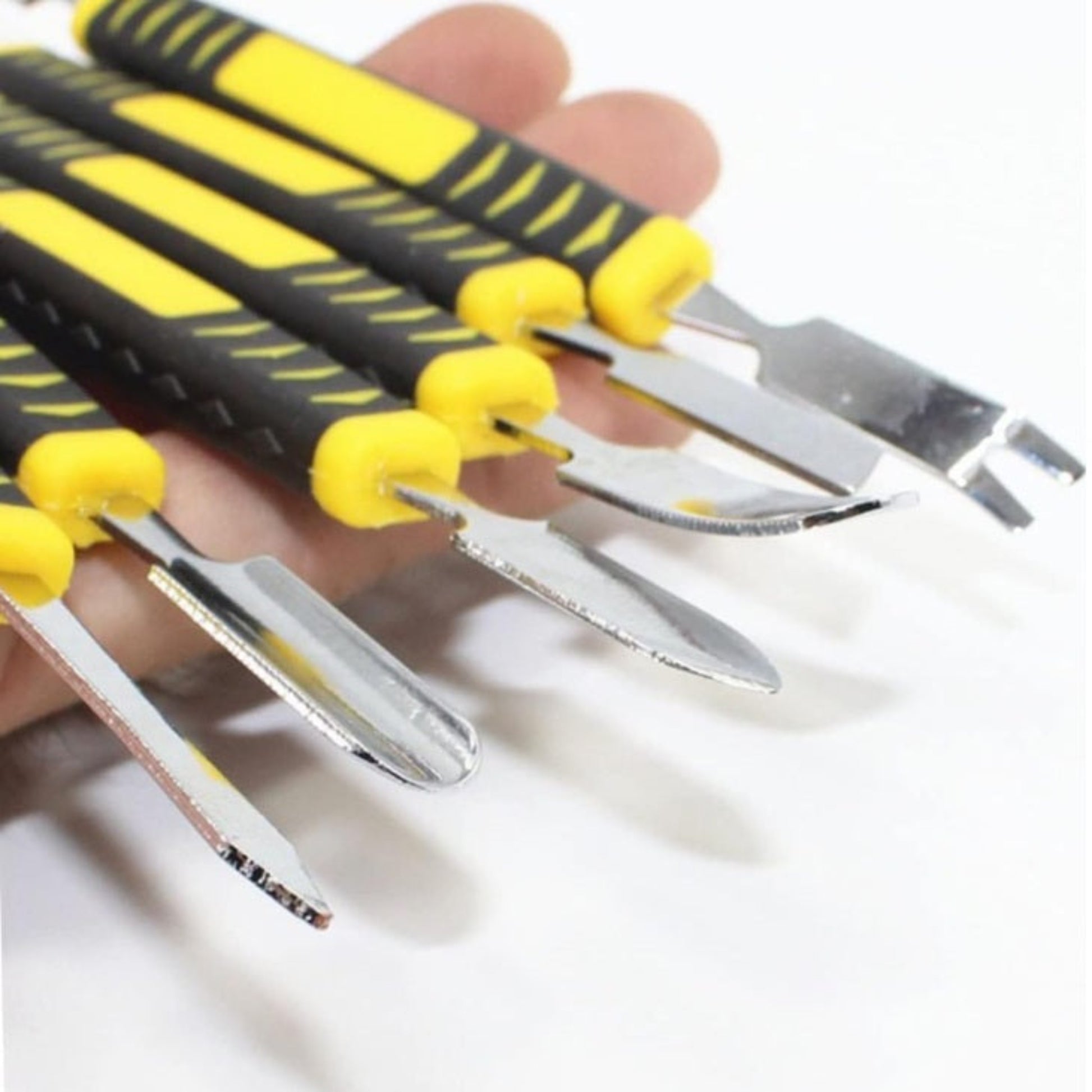 Close up of double-ended metal pry tool tips showing flat, pointed, and forked shapes.
