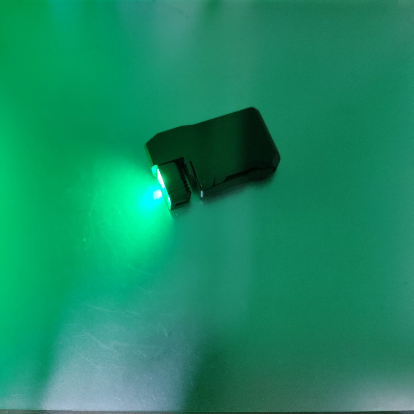 The army green EDC mini flashlight projecting its maximum 400 lumen bright white light.