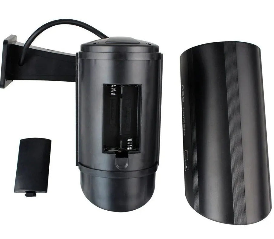 Inside view of a black dummy camera showing the AA battery compartment.