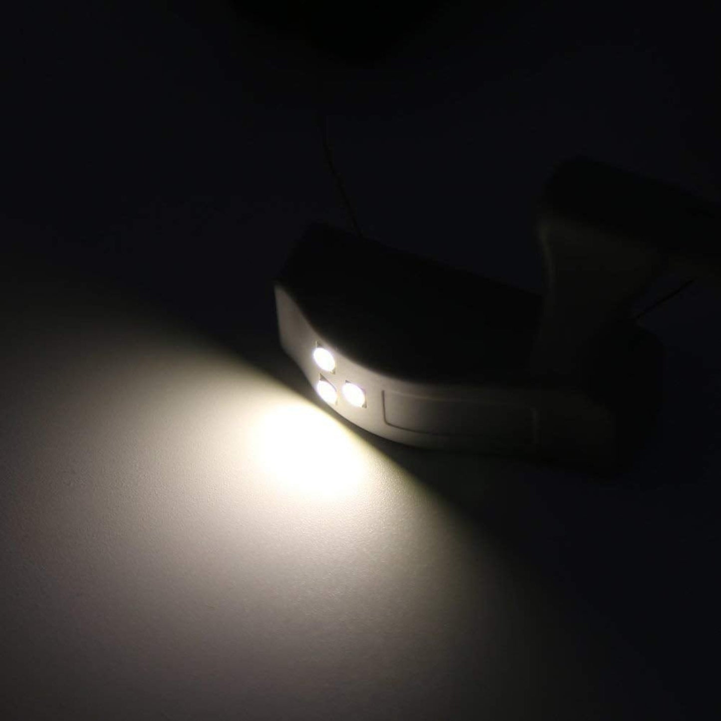 Cabinet hinge LED light illuminating a surface with warm white light, designed for modern kitchen cabinets.