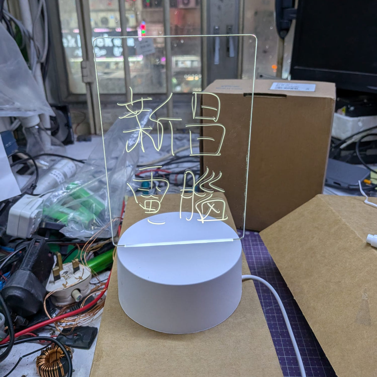 LED發光留言板亮起暖色燈光並顯示新昌電腦字樣，實體店提供即場測試及技術支援。