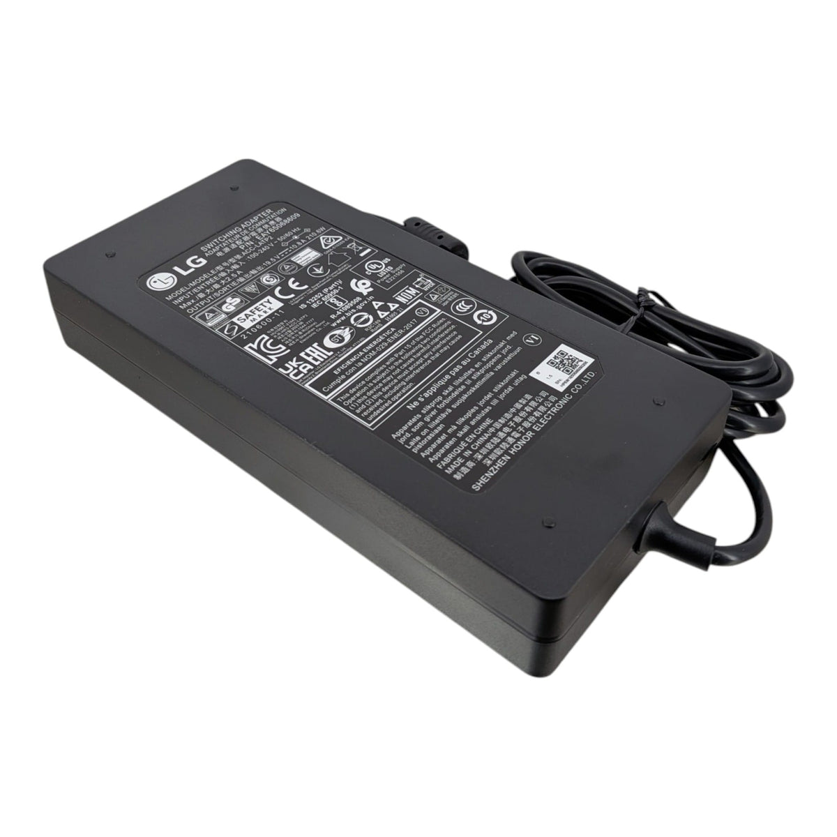 LG OEM 19.5V 10.8A (210W) 火牛的傾斜視圖，展示黑色機身、規格標籤及附帶防干擾磁環的 DC 輸出線。