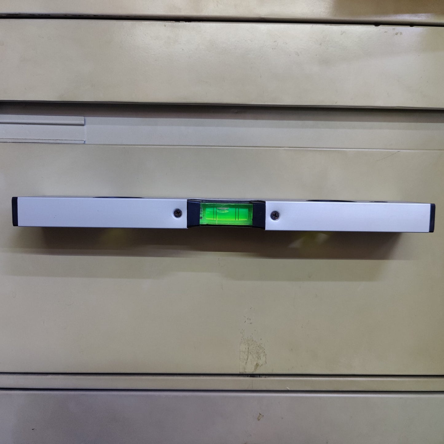 30cm spirit level attached to a metal surface demonstrating hands-free use with its strong magnetic base.