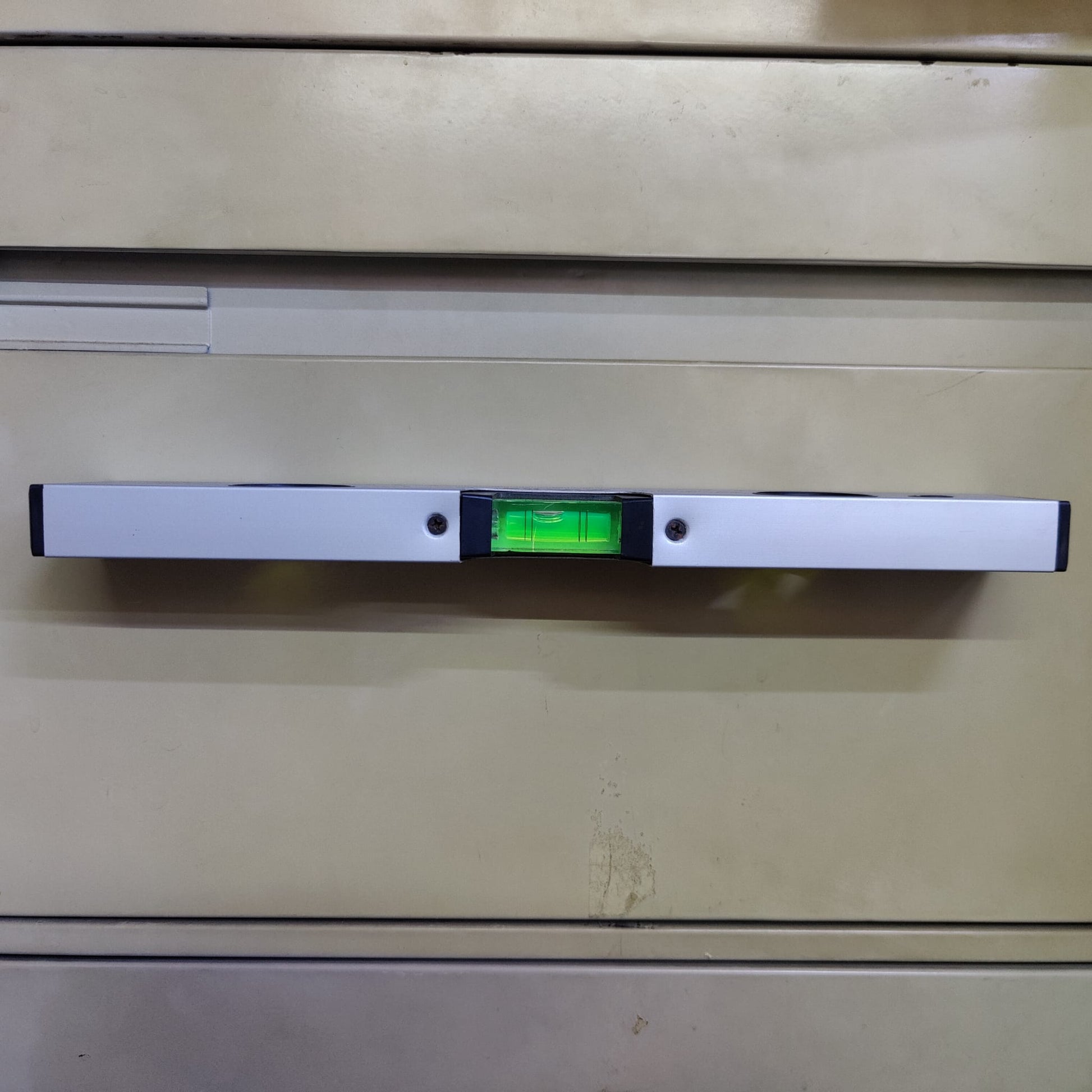 30cm spirit level attached to a metal surface demonstrating hands-free use with its strong magnetic base.