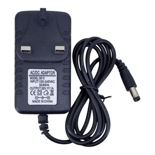 Black 30V 1A power adapter model 3010 with UK plug pins, specification label, and bundled cable with a 5.5mm DC connector.