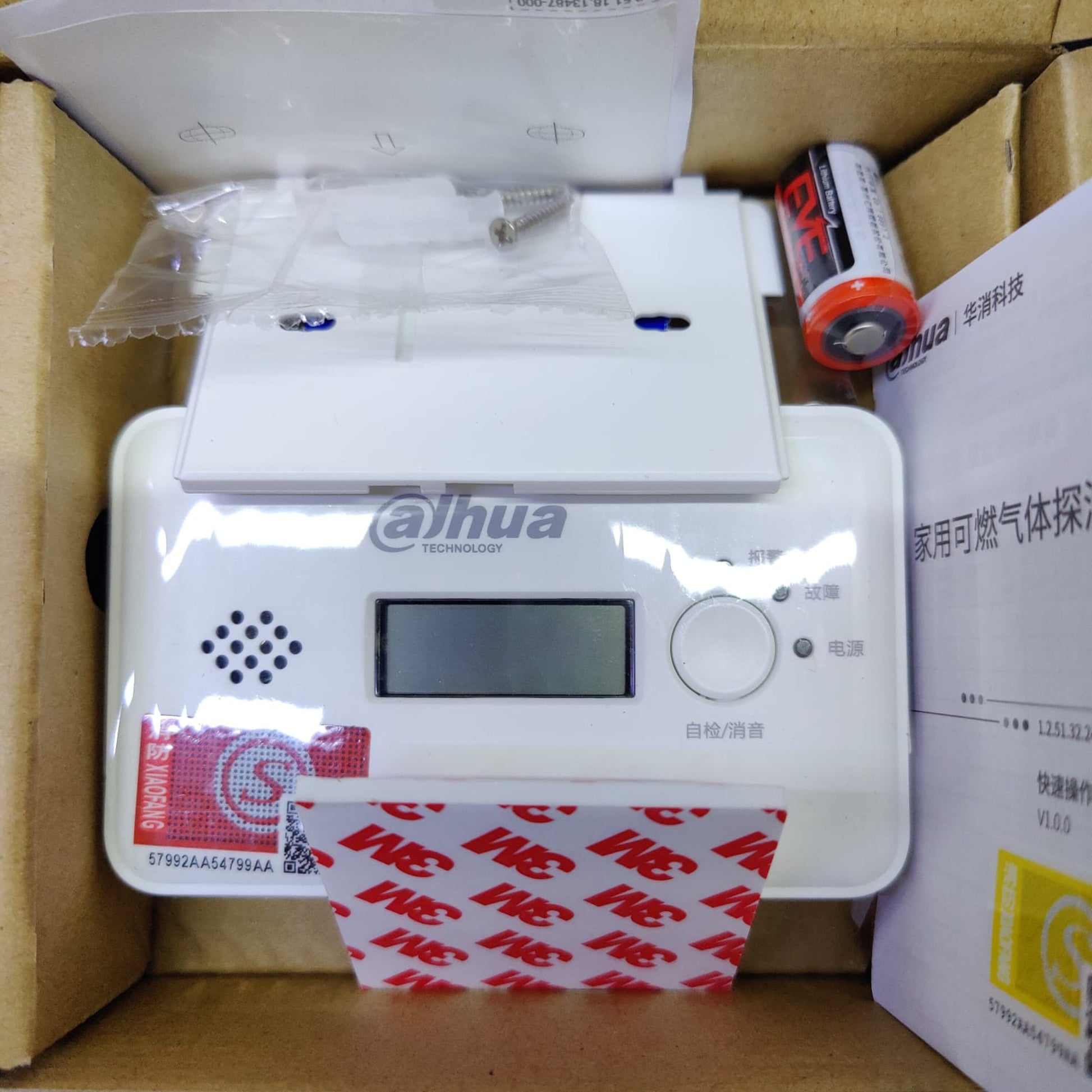 Unboxing view showing CR123A battery and 3M mounting tape