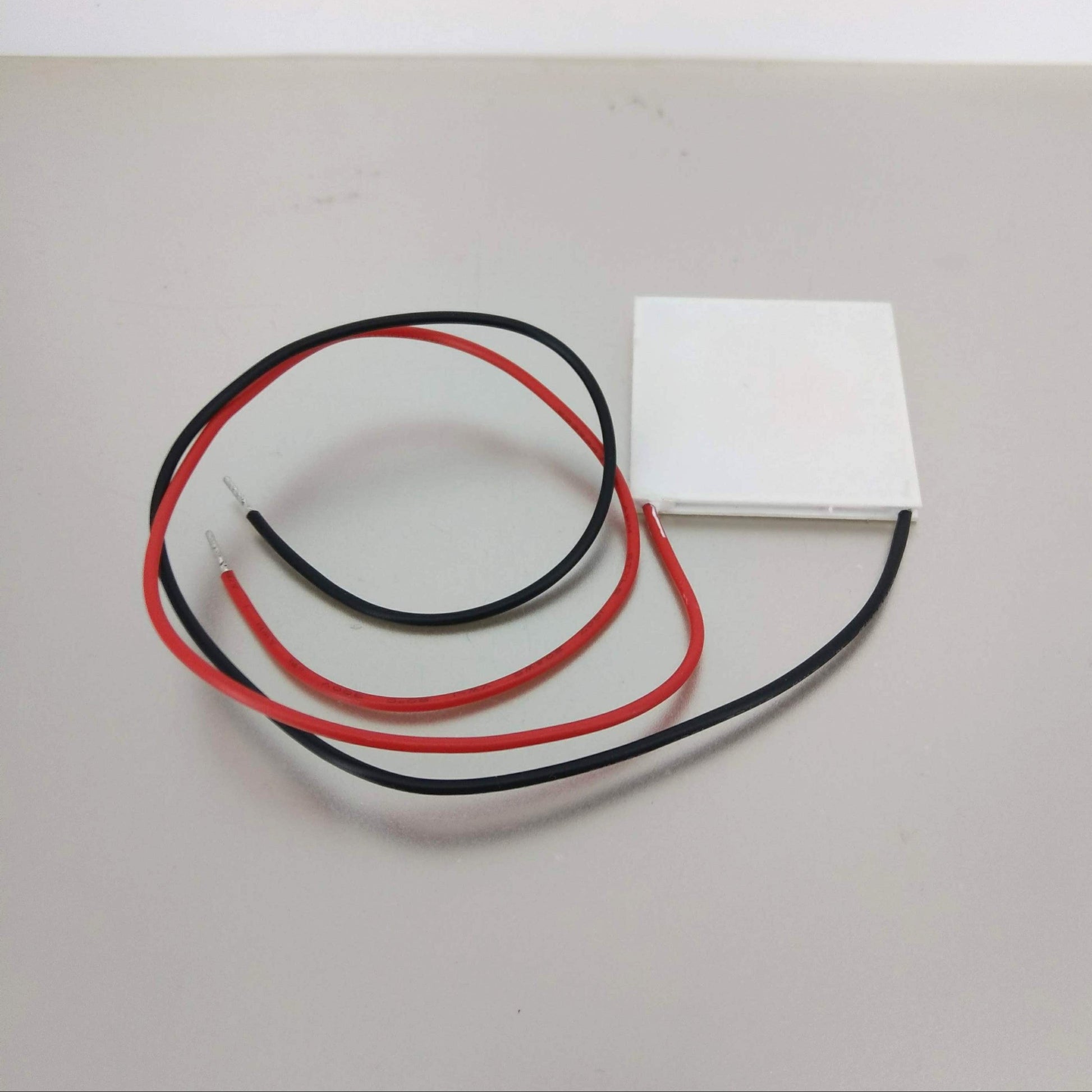 Detail of the TEC1-12712 Peltier chip showing red (positive) and black (negative) 12A power wires.