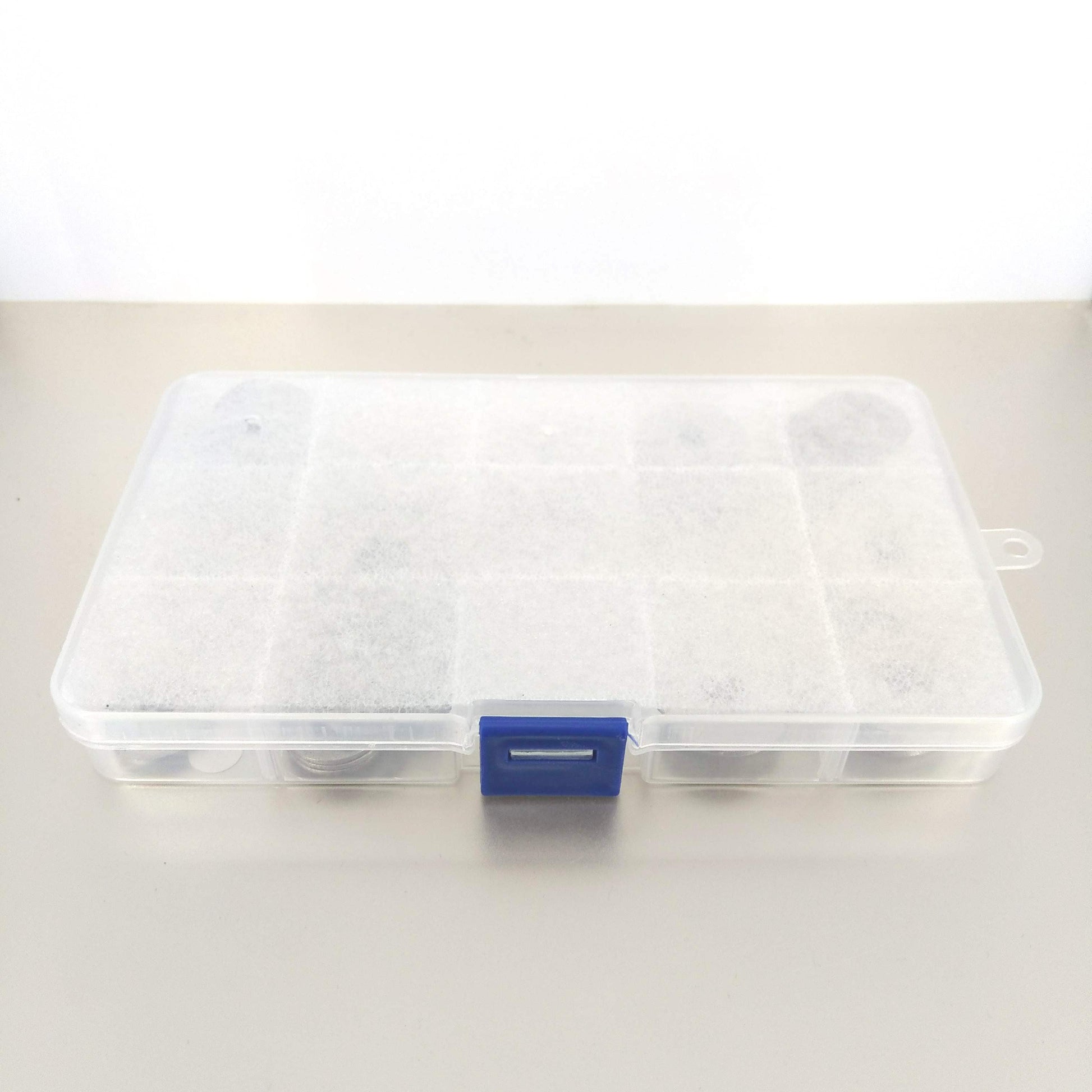 Closed transparent storage box containing stainless steel hardware washers.