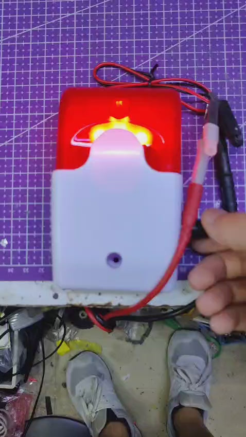 12V alarm actively flashing its red LED strobe light