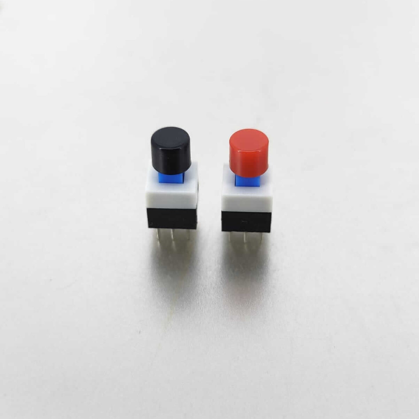Two tactile mini push button switches in black and red, 8x8mm size, with 6-pin configuration for electrical applications.
