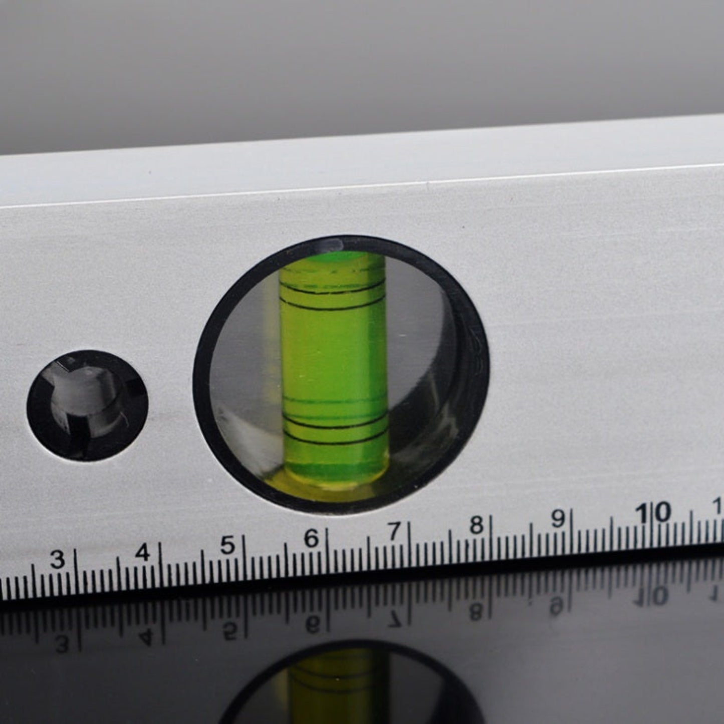 Detailed view of the 90-degree plumb vial and metric measurement scale on a 300mm level tool.
