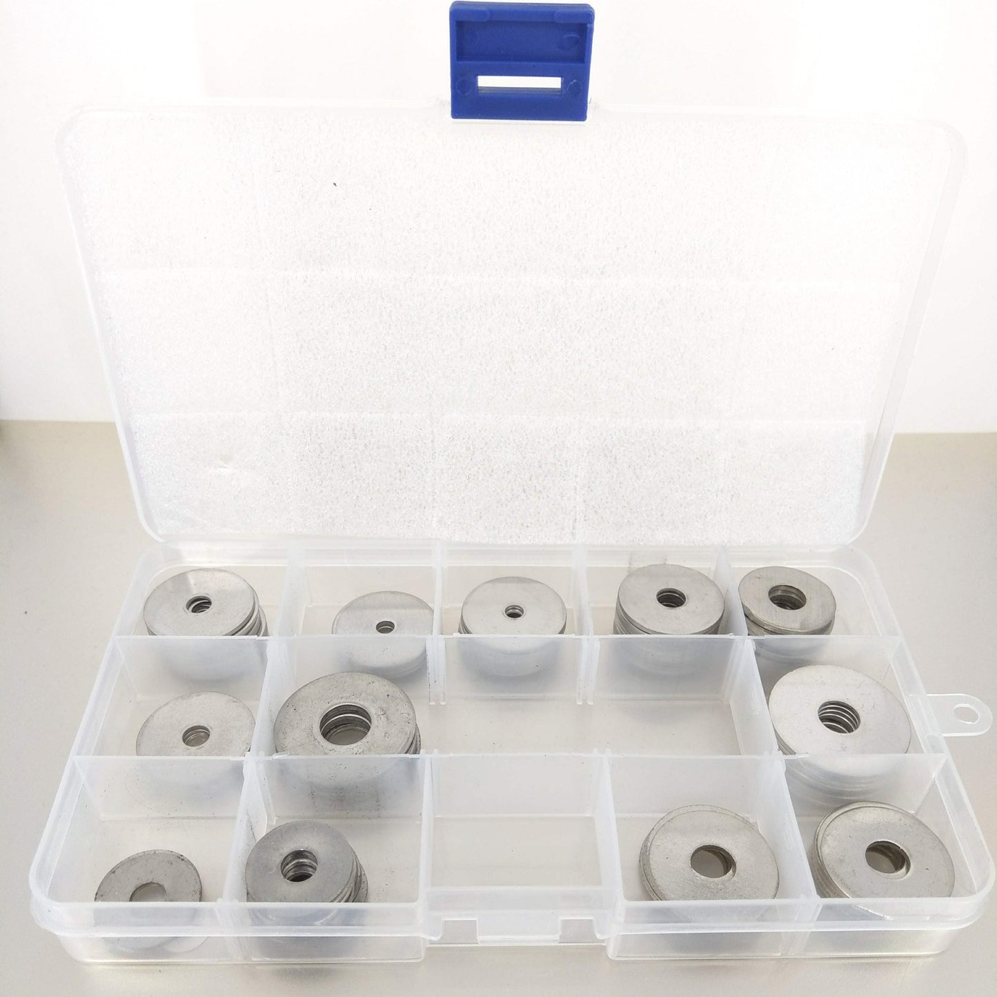 Front view of stainless steel flat washers sorted by size in a plastic case.