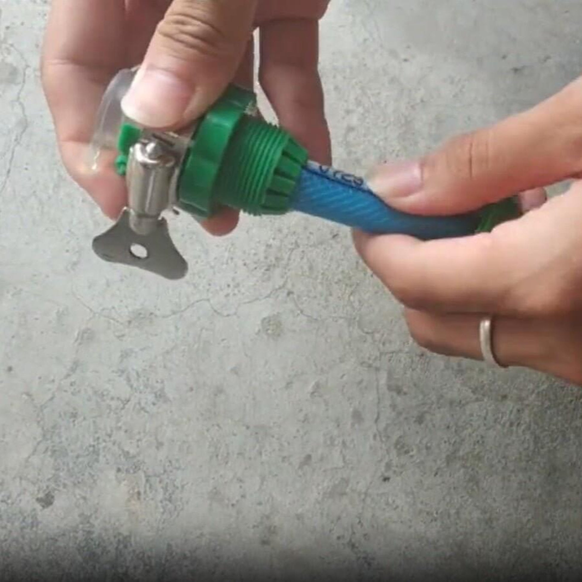 Person connecting a universal faucet adapter to a garden hose for irrigation use.