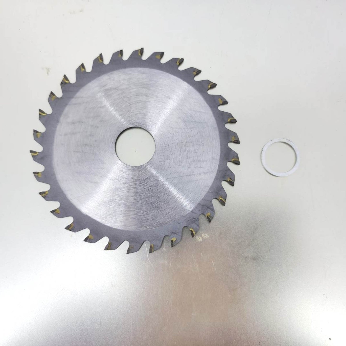 4 inch 110mm saw blade with 30 teeth for cutting hardwood, displayed on a metallic surface.